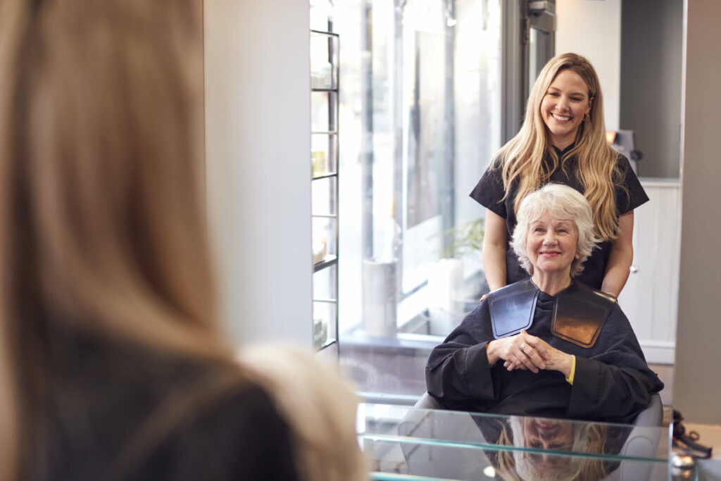 A mature woman consulting with a hair stylist about selecting the ideal hair topper