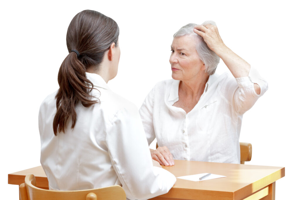 Woman discussing hair thinning concerns with doctor in office