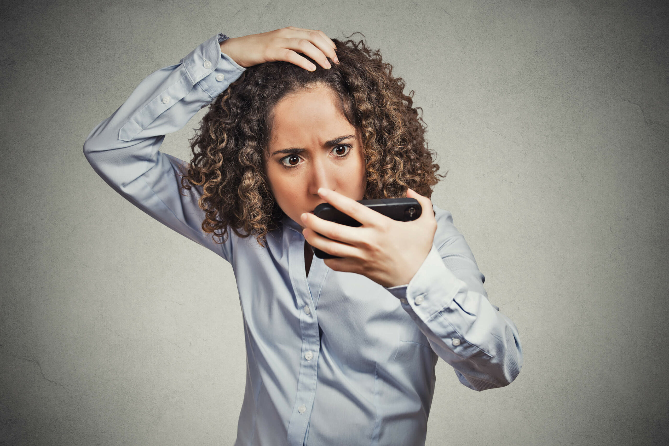 Woman looks at her hair line - frontal fibrosing alopecia causes a receding hairline