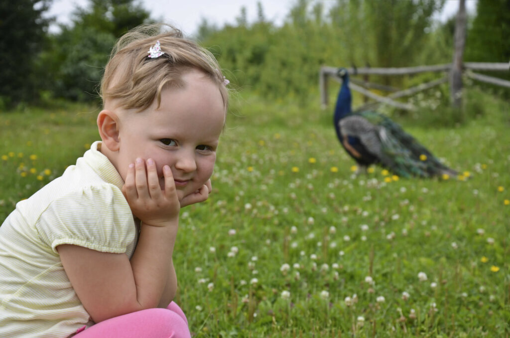 A young girl plays outside. She is experiencing hair loss due to alopecia areata